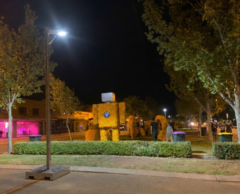 a mobile solar lighting tower lighting a street near a park