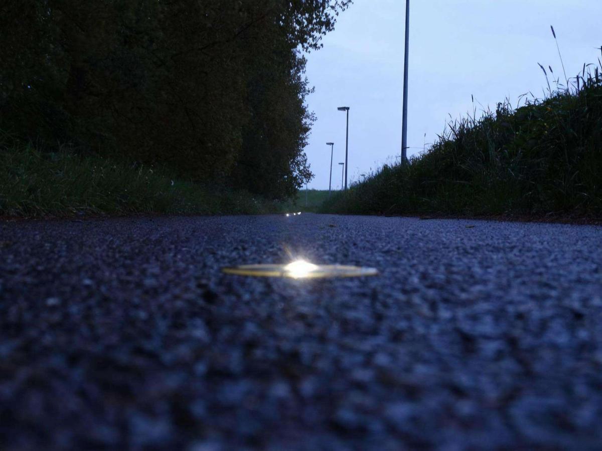 an in-ground solar stud light in a road